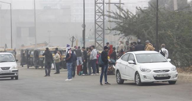 कड़ाके की ठंड में खुले आसमान के नीचे बसों का इंतजार करने को मजबूर सवारियां